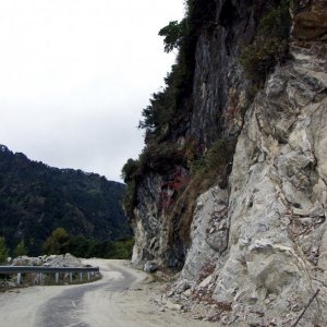 The road is cut out along a ledge on the cliff face of Narling Dra, Bhutan