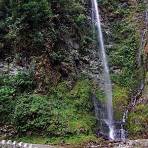 The road is cut out along a ledge on the cliff face of Narling Dra, Bhutan