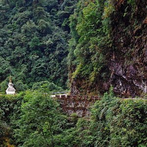The road is cut out along a ledge on the cliff face of Narling Dra, Bhutan